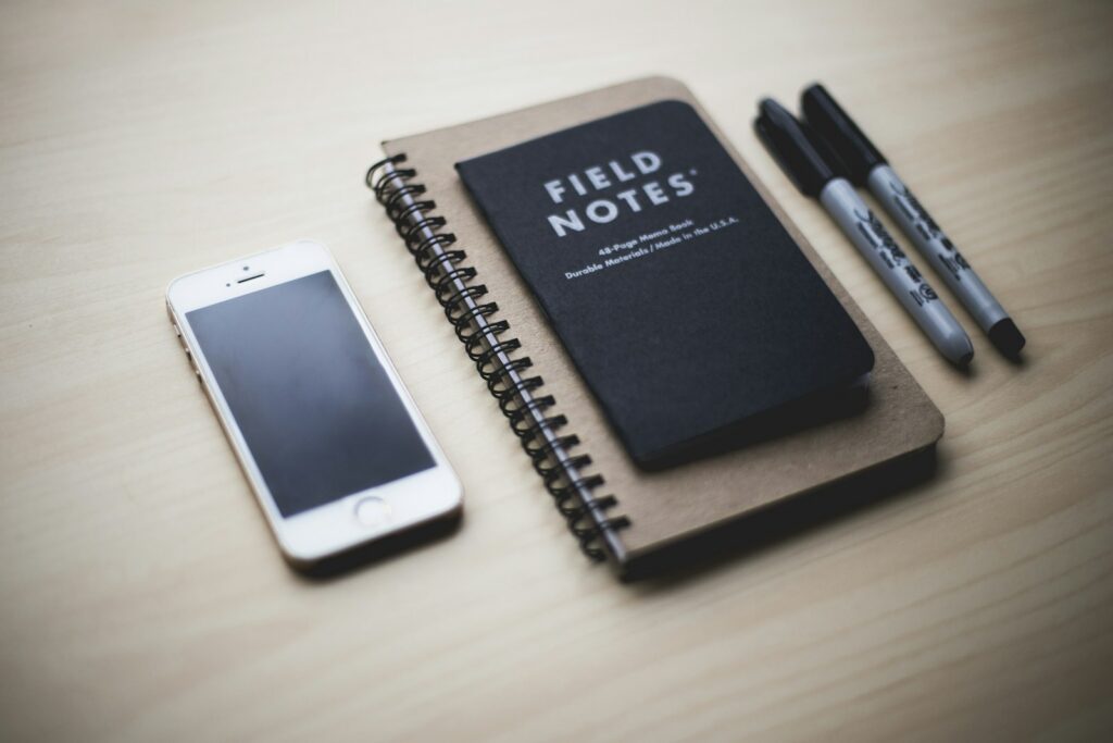 A smartphone resting on a notebook on a desk