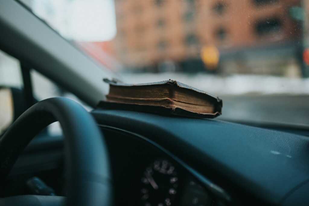 Open driver handbook on car dashboard for DMV written test study