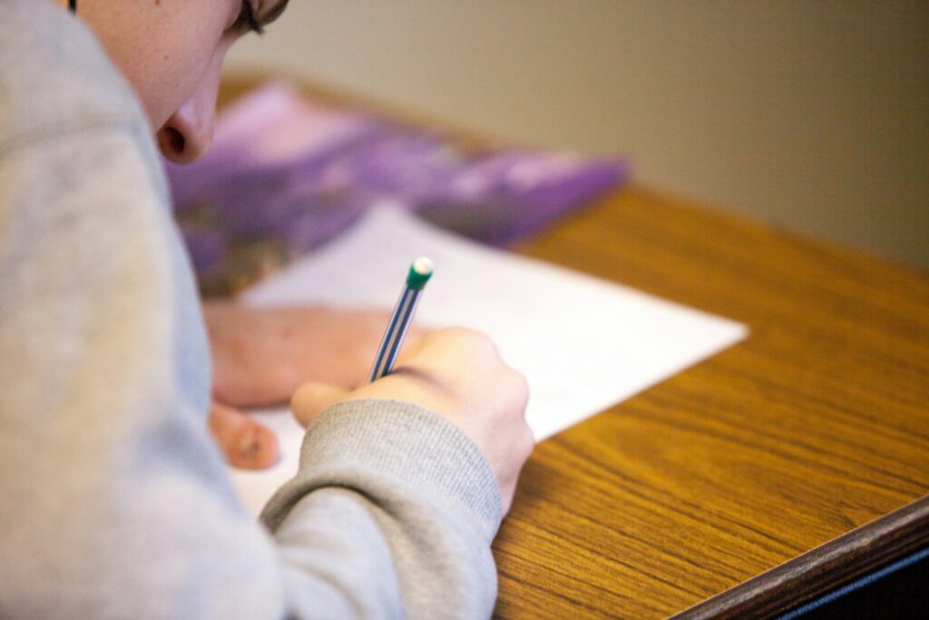 Person studying with pencil and notes for an exam