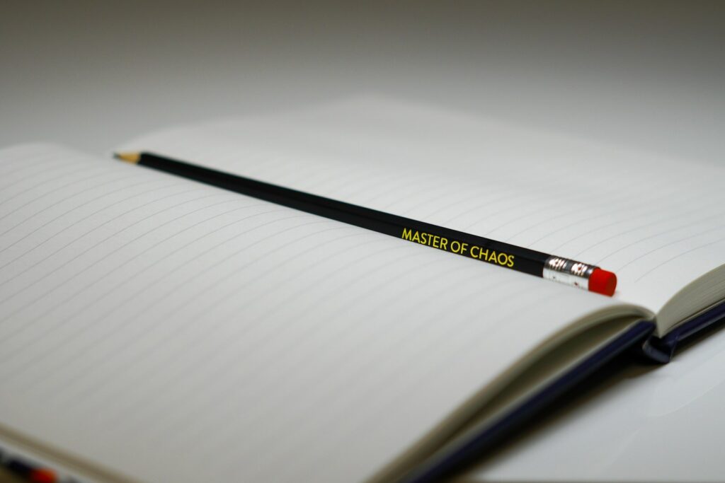 A pencil sitting on top of an open notebook