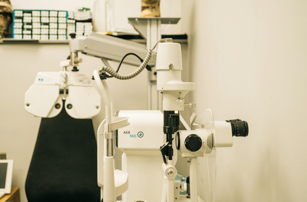 An optometry exam room with a phoropter, chart screen, and testing chair