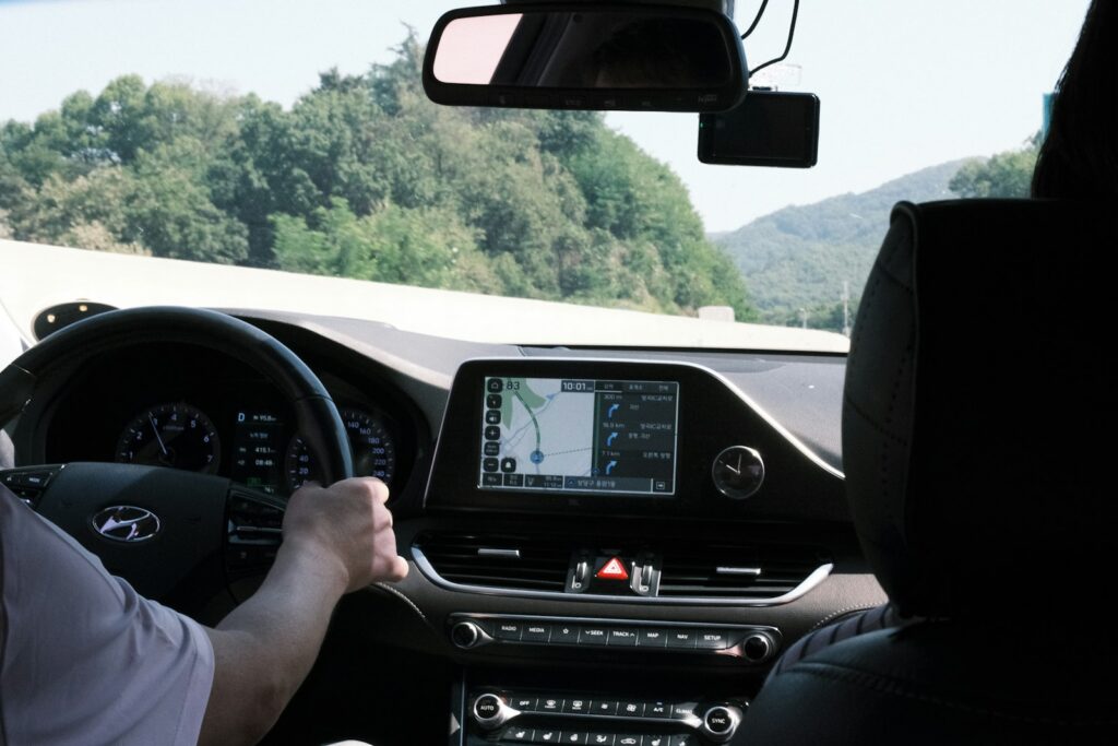 View through a car windshield of the road ahead with the dashboard in frame