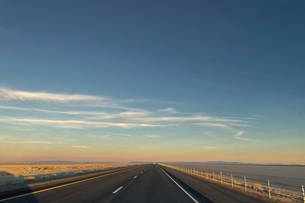 A multi-lane highway with cars driving under a cloudy sky