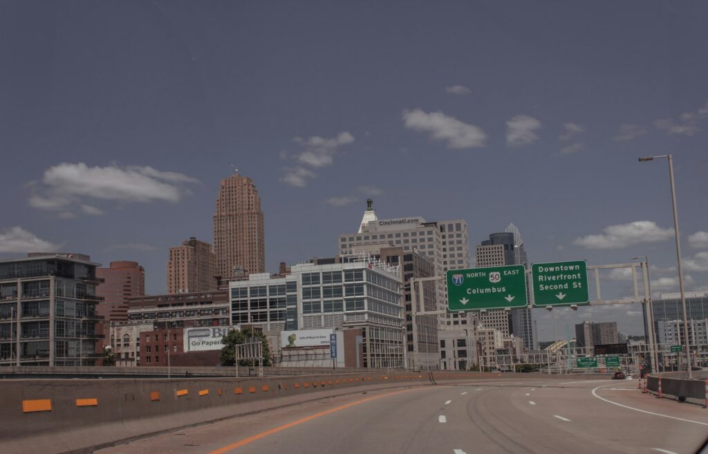 A city skyline seen from a multi-lane highway under a clear sky