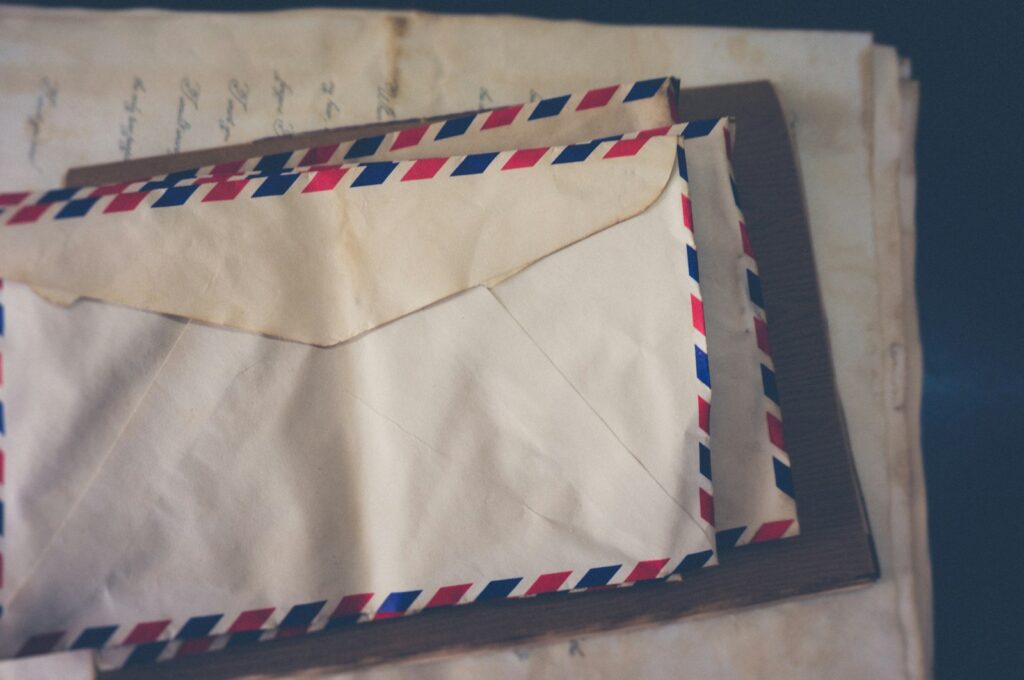 A white window envelope resting unopened on a plain light surface